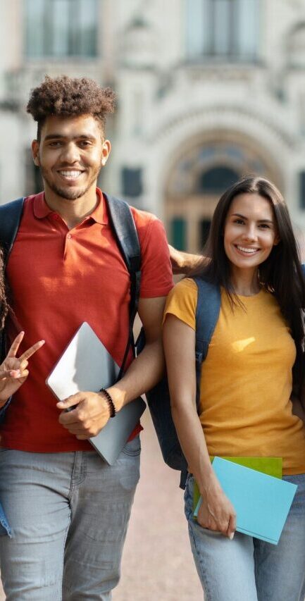 group of happy international students posing outdoors near university building e1770649783954