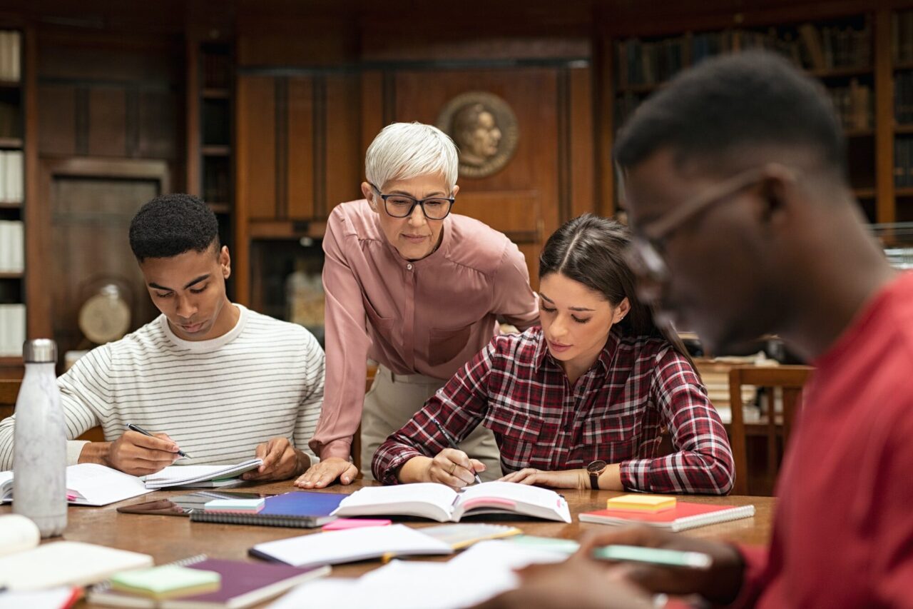 university students studying with teacher
